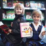 two children in the library holding books