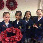 four children holding a poppy wreath