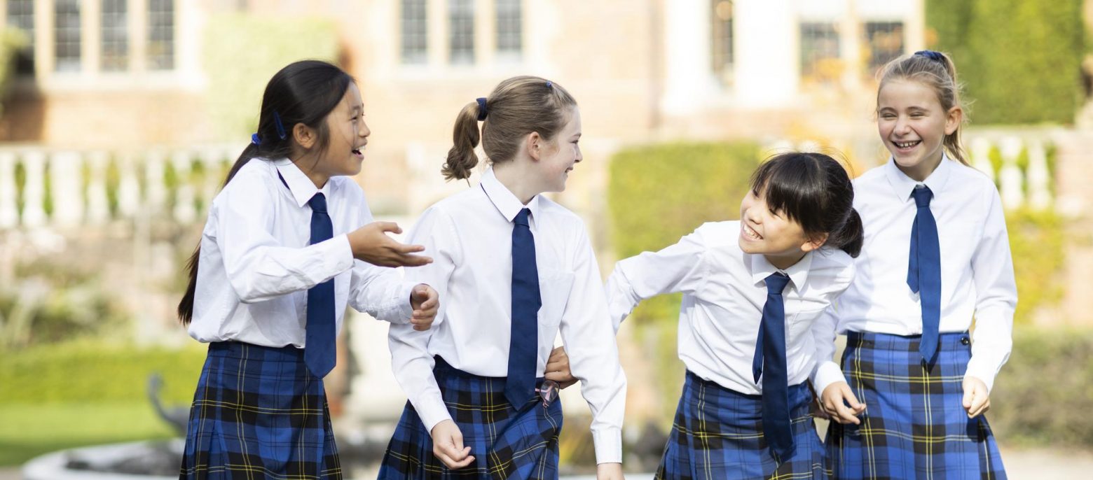 4 students walking along the school grounds