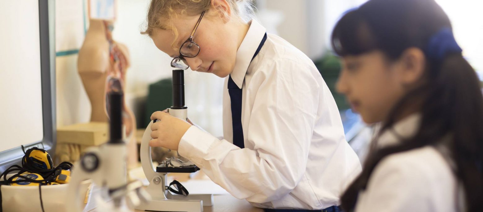 student looking through a microscope