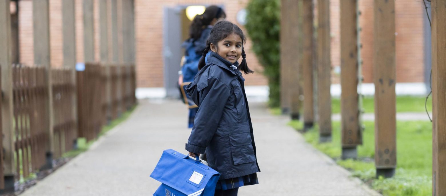 school girl holding a book back