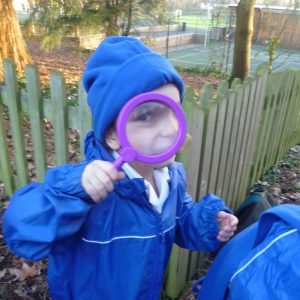 child looking through a magnifying glass