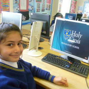 child sitting at a computer in a school ICT suite
