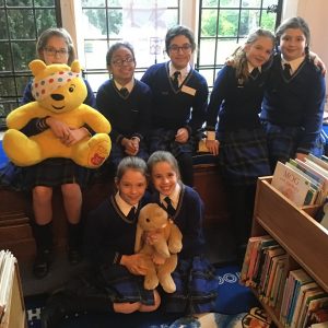 girls holding pudsy the bear and a bunny toy