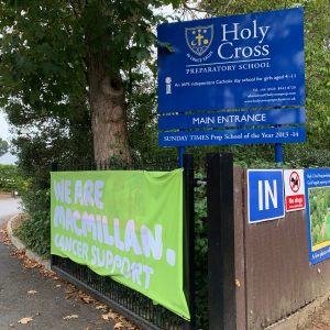 Outside of Holy Cross School with the Macmillan Banner
