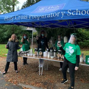 Holy Cross teachers under a tent giving out coffee