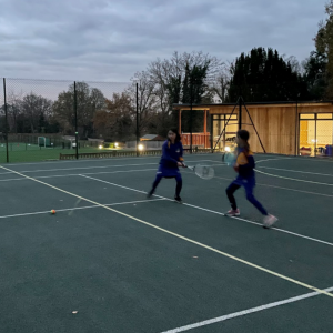 2 girls in a team playing tennis