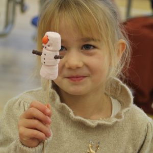 child holding a stick with a marshmallow