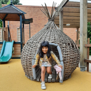 Child coming out of a wicker made den