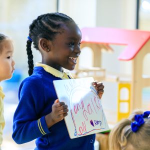 child holding her drawing