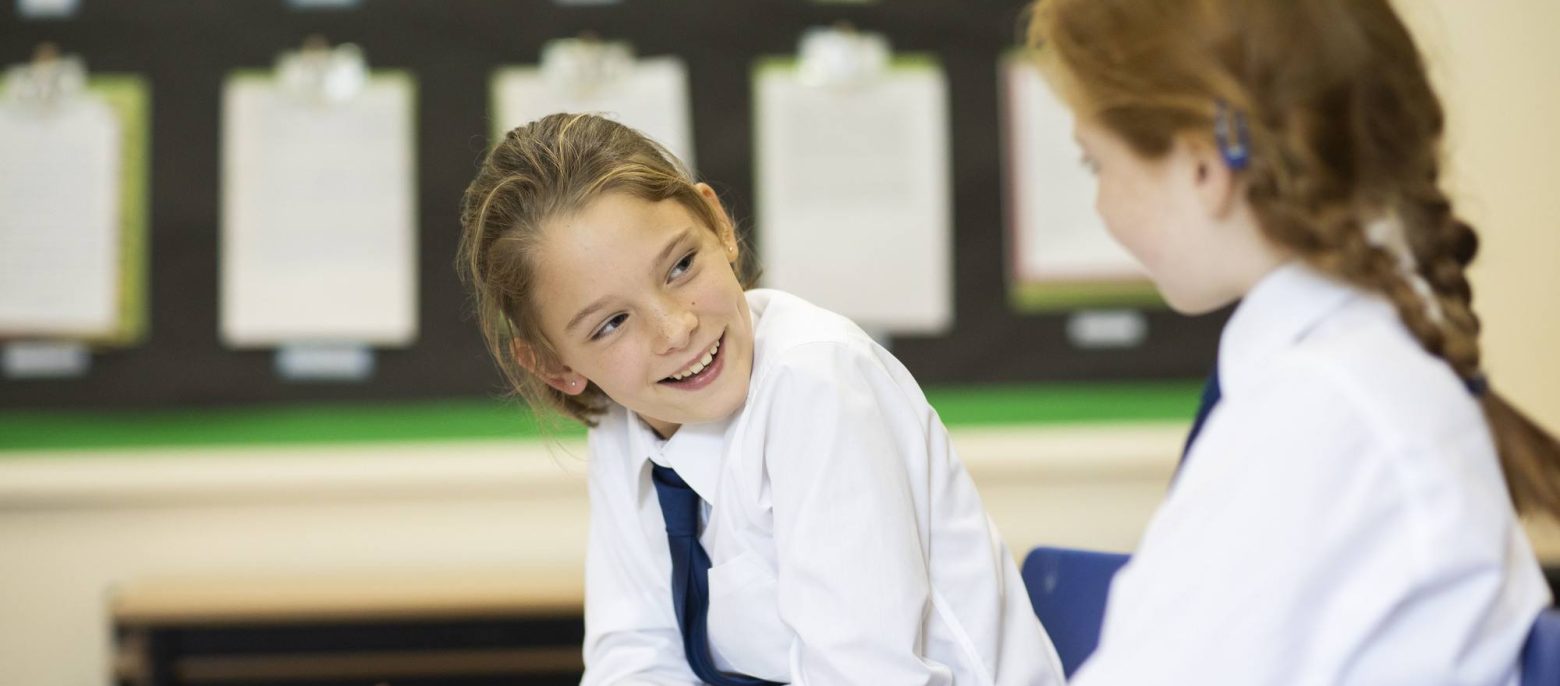 students smiling at each other in class