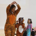 student and a teacher dressed in tiger onesies